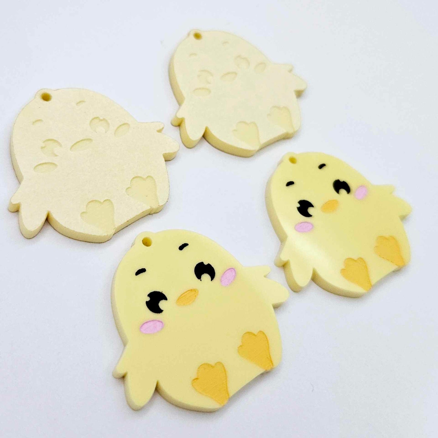 Pastel yellow acrylic chicken dangle blanks with engraved face and feet, two paint filled and two with protective film on