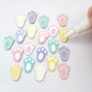 white and pastel bunny paw print stud blanks showing some paint filled and several unpainted pieces, with a Light Pink and White Posca paint pen included in the image