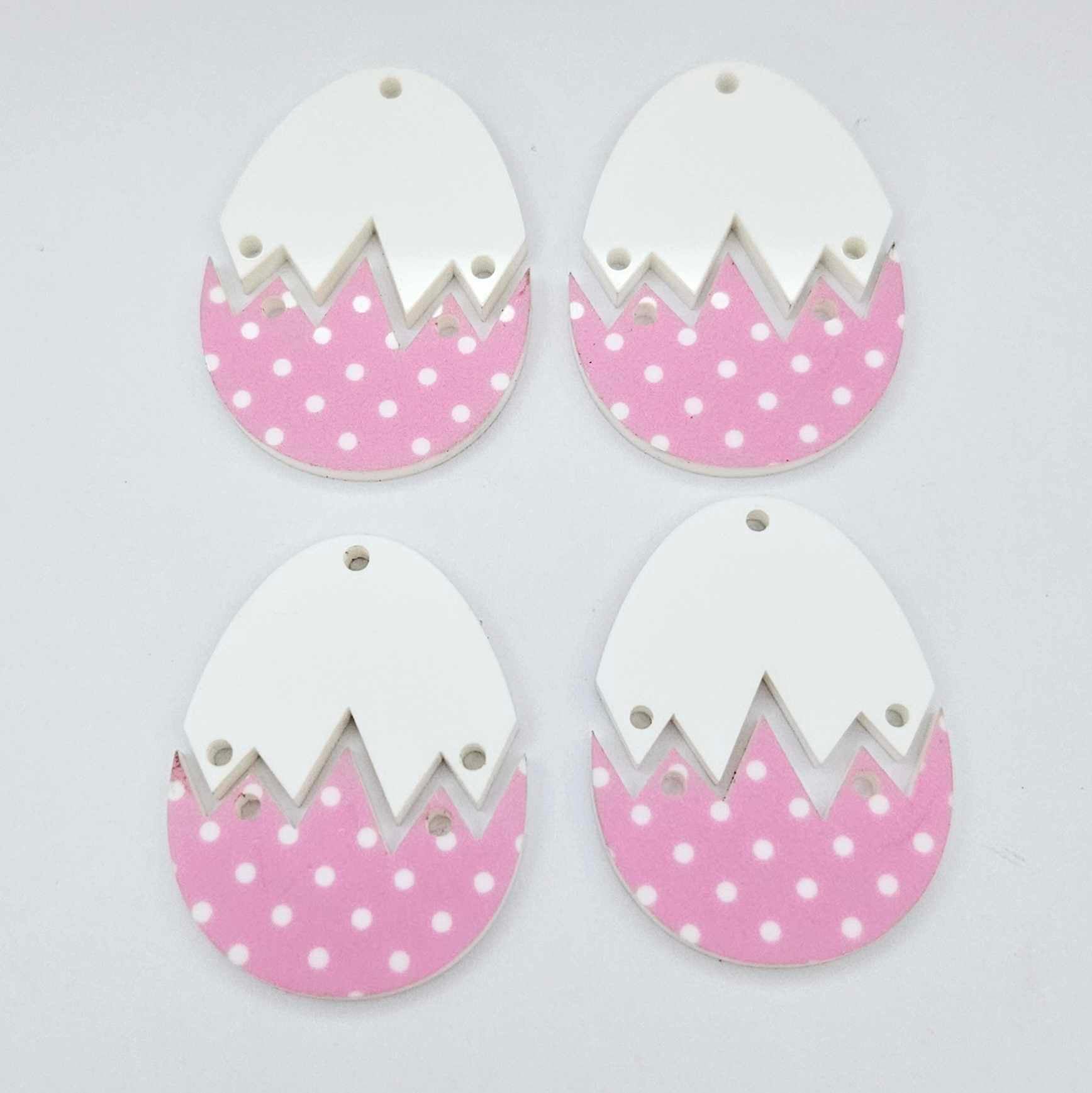 Four cracked egg earring blanks unassembled, white top halves and pastel pink polka dot UV printed bottom halves