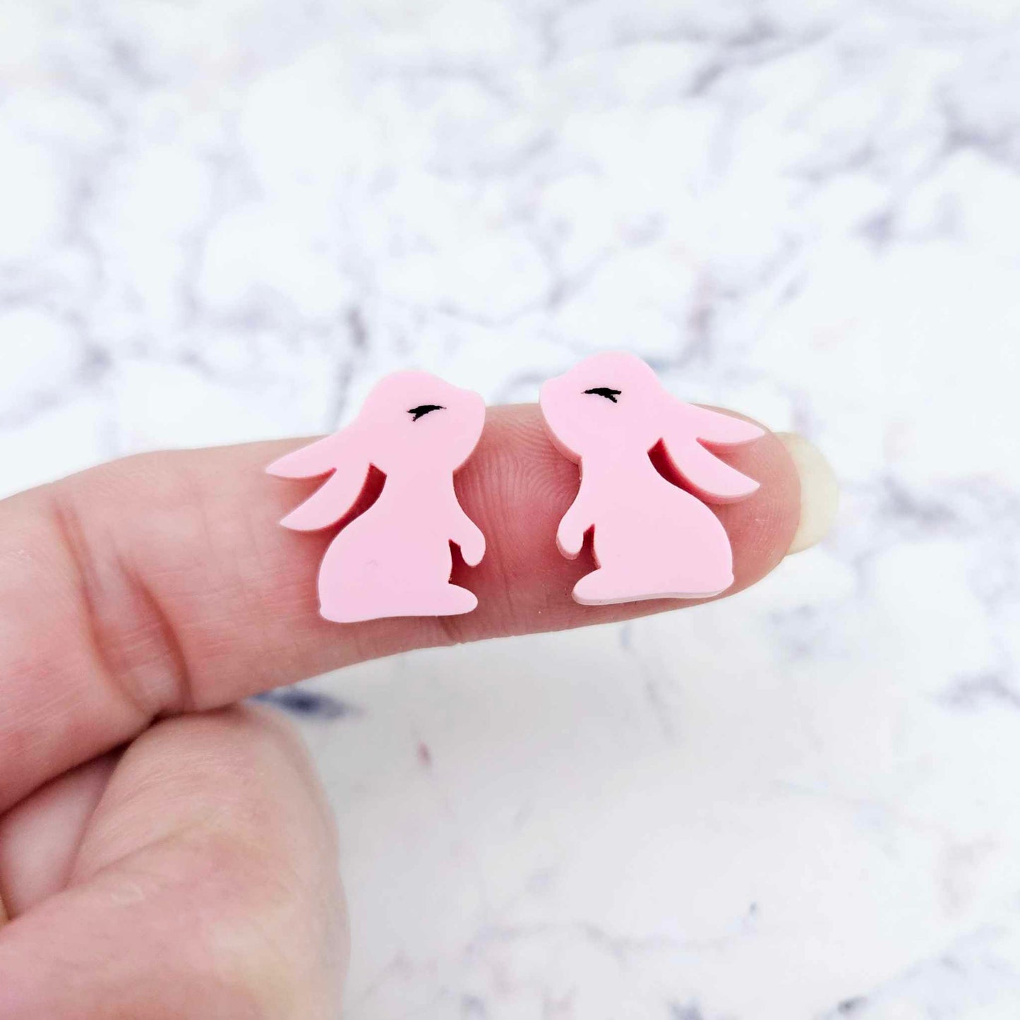 Close-up of pastel pink acrylic bunny stud blanks with paint filled eyelashes