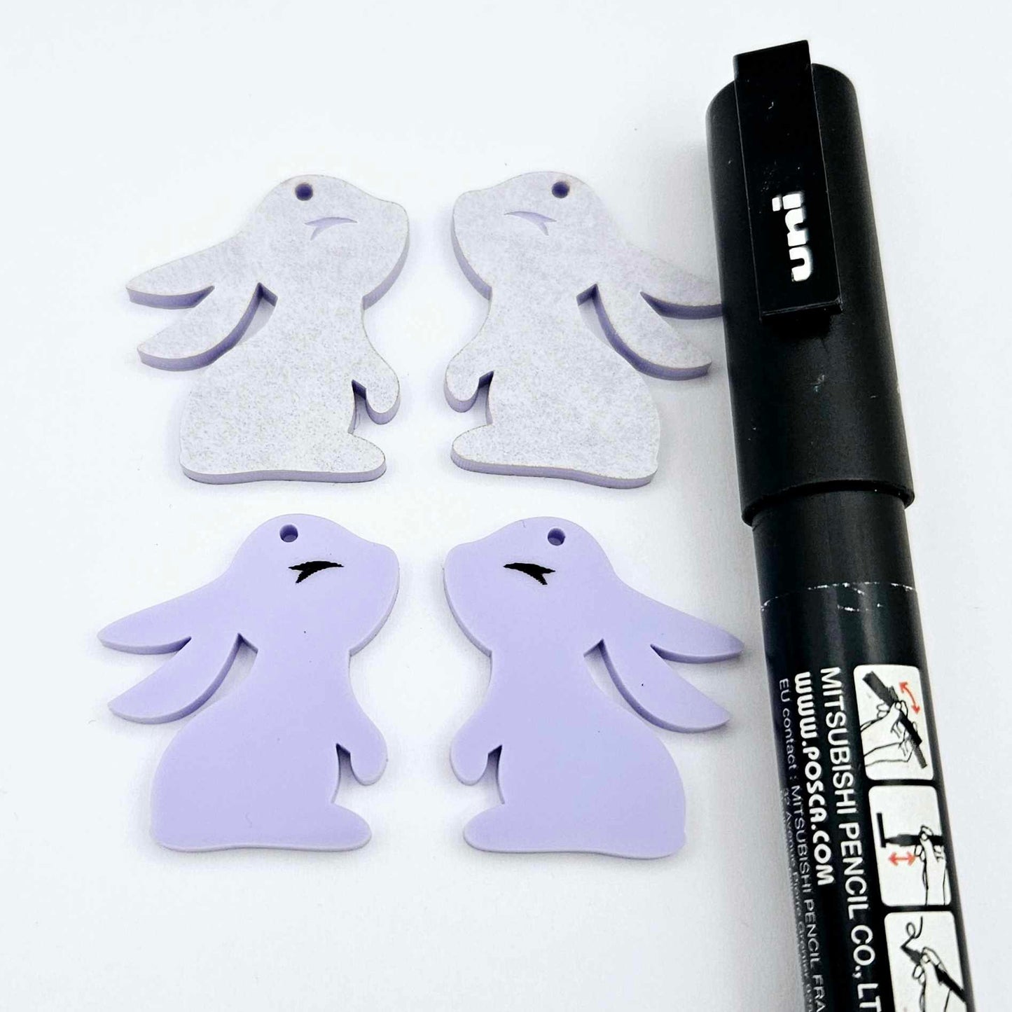 32mm pastel purple bunny dangle blanks showing paint filled black eyelashes on two pieces, with remaining pieces shown with protective paper as supplied