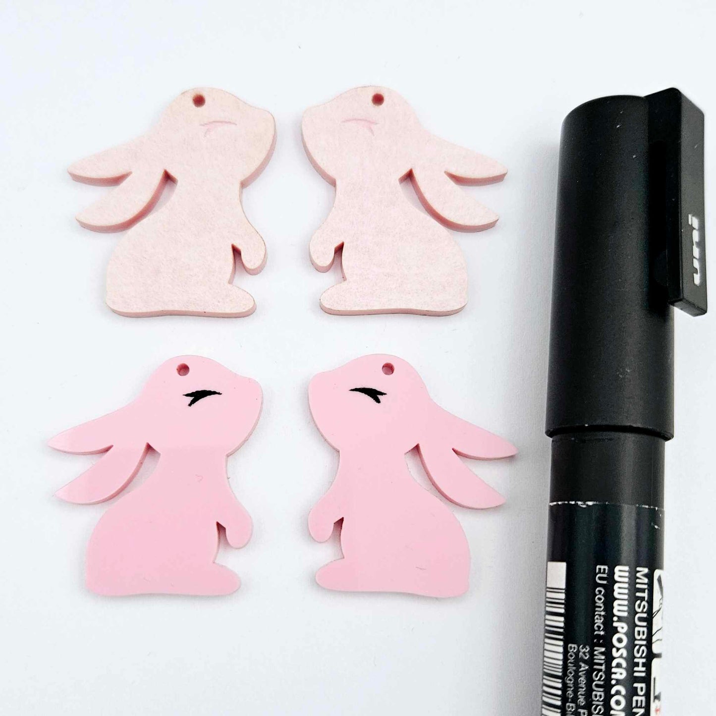 32mm Pastel pink bunny dangle blanks showing paint filled black eyelashes on two pieces, with remaining pieces shown with protective paper as supplied