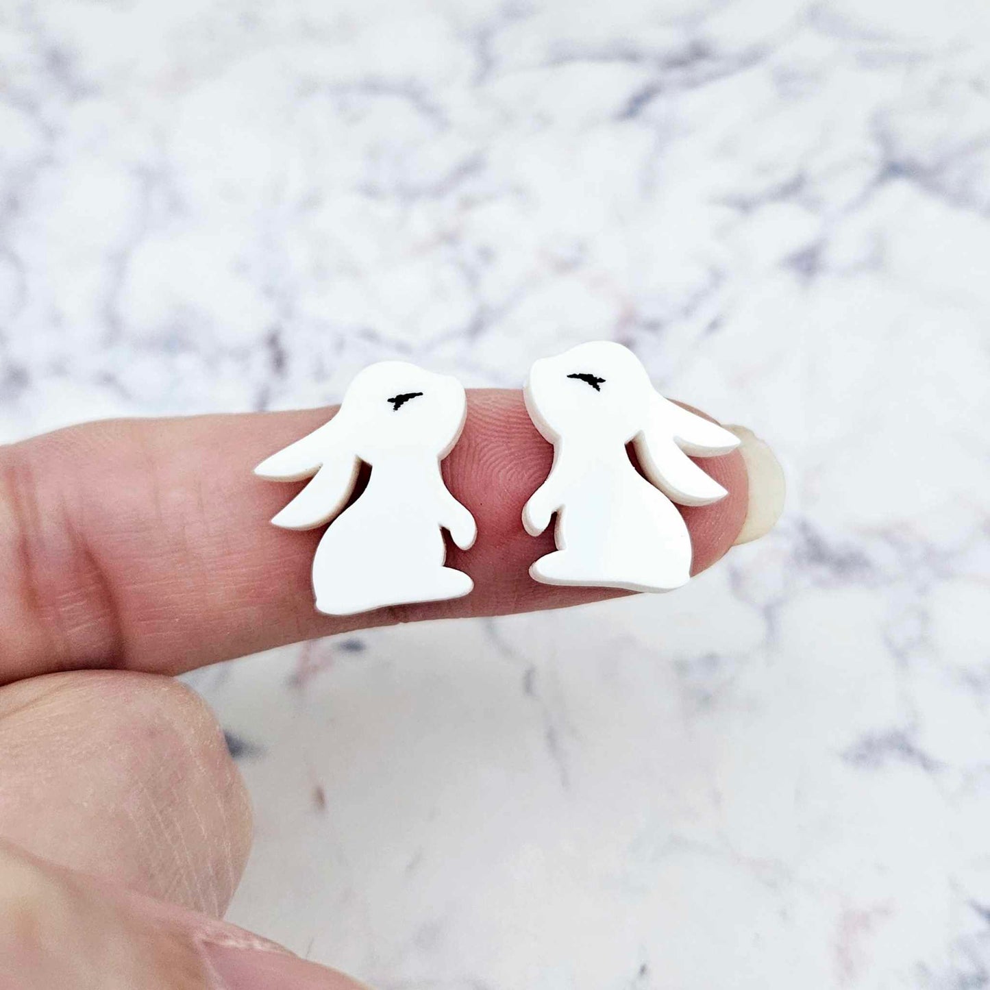 Close-up of white acrylic bunny stud blanks with paint filled eyelashes