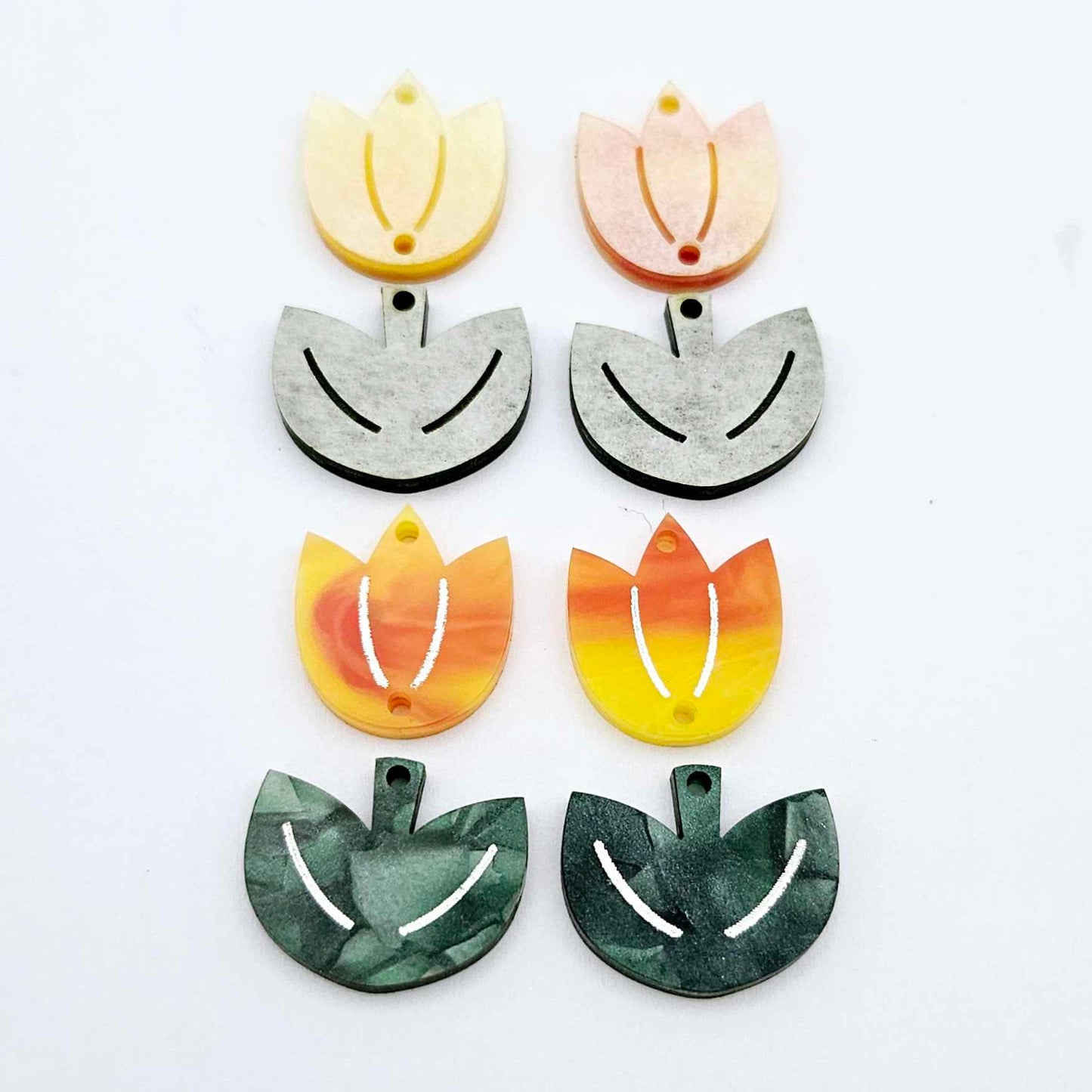Two-piece tulip acrylic dangle blanks in orange artist swirl and green mineral acrylic, paint filled white on one pair with remaining pair unfilled