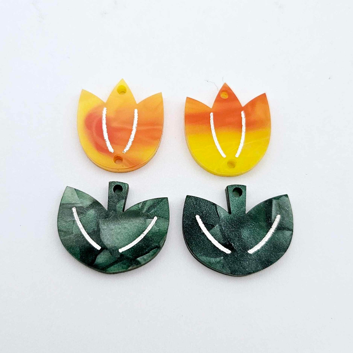 Two-piece tulip acrylic dangle blanks in orange artist swirl and green mineral acrylic, paint filled white on one pair