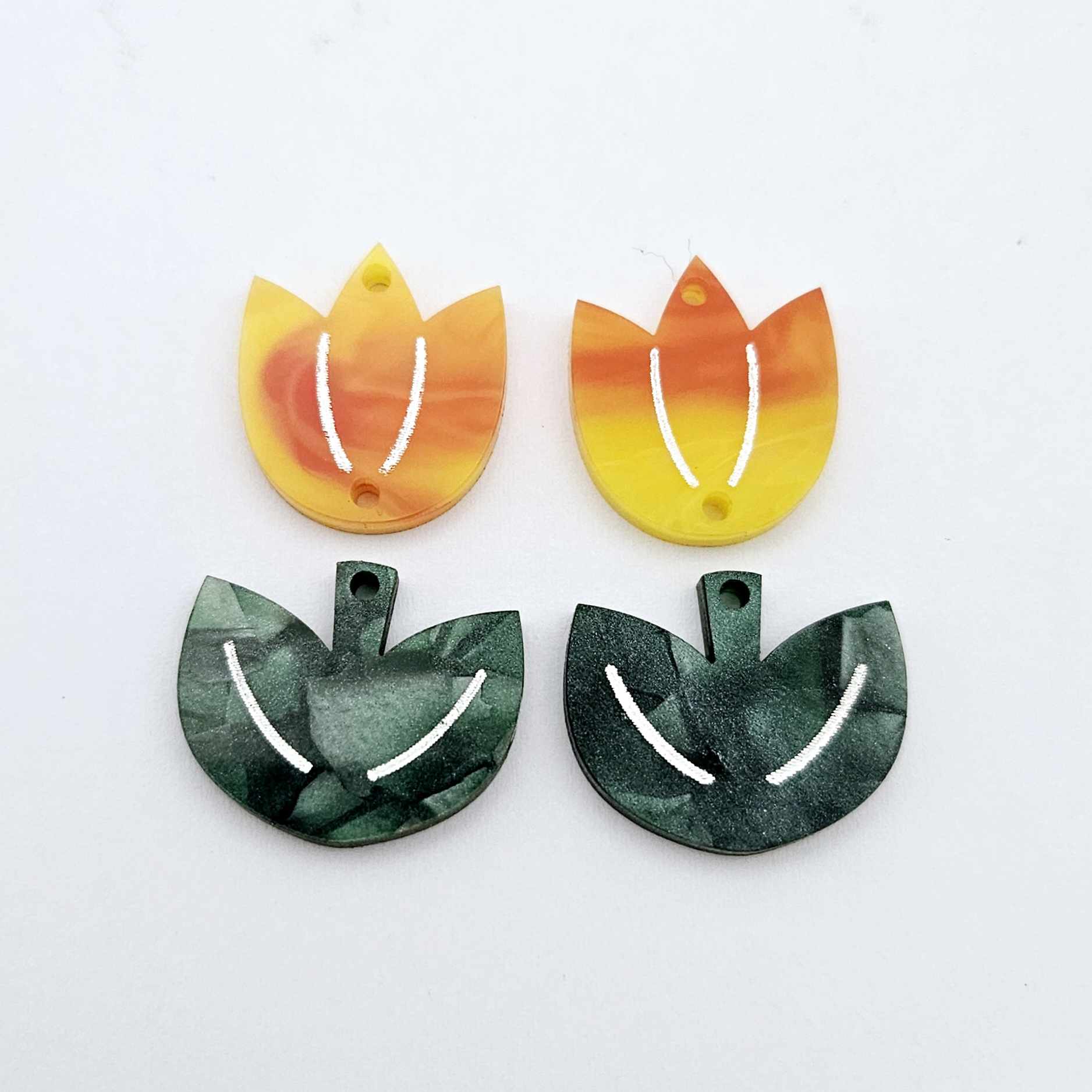 Two-piece tulip acrylic dangle blanks in orange artist swirl and green mineral acrylic, paint filled white on one pair