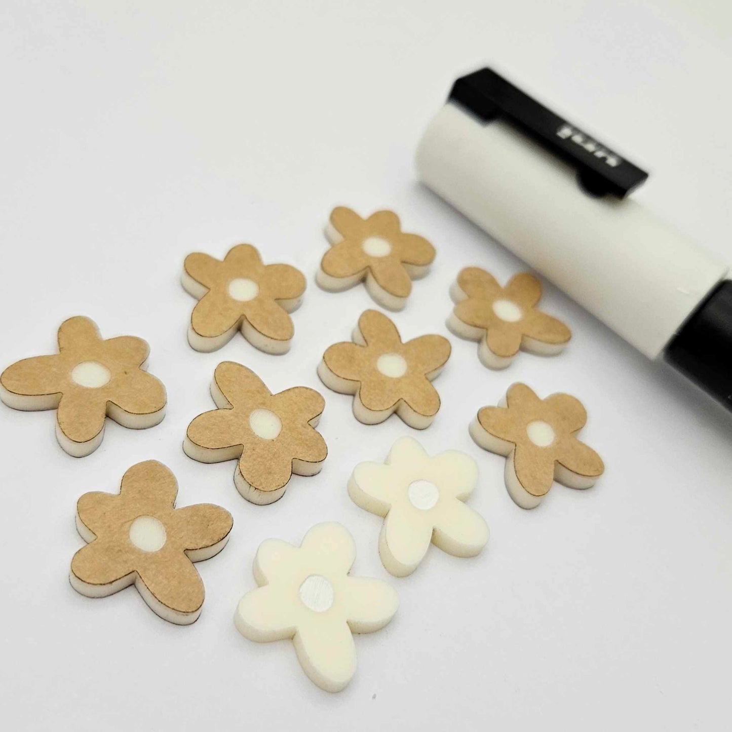 16mm cream organic flower stud blanks showing paint filled white example and unfilled pieces with protective film, pictured with a white Posca paint pen