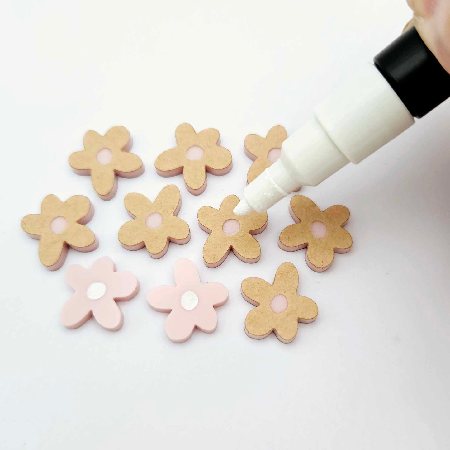 16mm dusty pale pink organic flower stud blanks showing paint filled white example and unfilled pieces with protective film, pictured with a white Posca paint pen