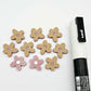 16mm dusty rose organic flower stud blanks showing paint filled white example and unfilled pieces with protective film, pictured with a white Posca paint pen
