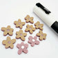 16mm dusty rose organic flower stud blanks showing paint filled white example and unfilled pieces with protective film, pictured with a white Posca paint pen