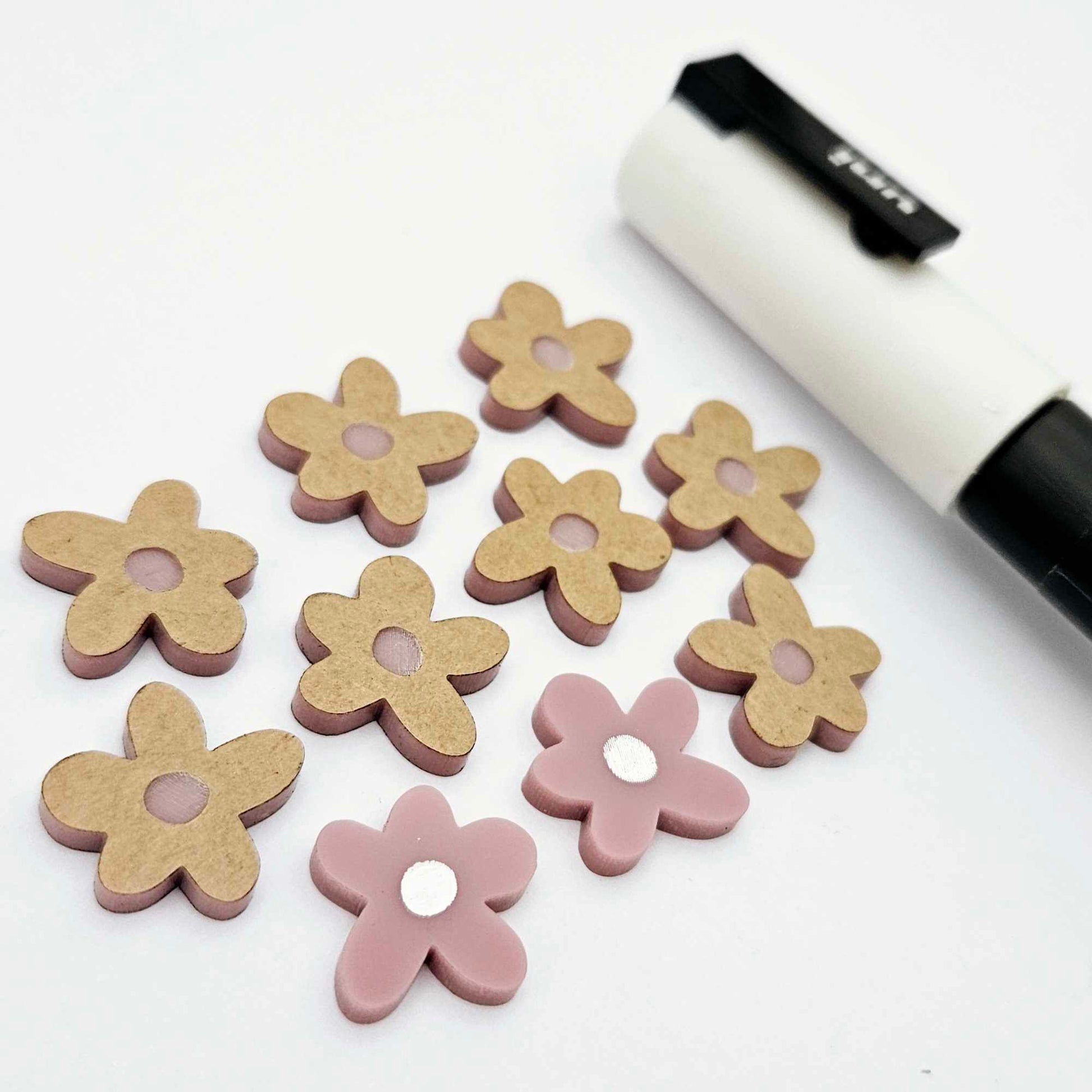 16mm dusty rose organic flower stud blanks showing paint filled white example and unfilled pieces with protective film, pictured with a white Posca paint pen