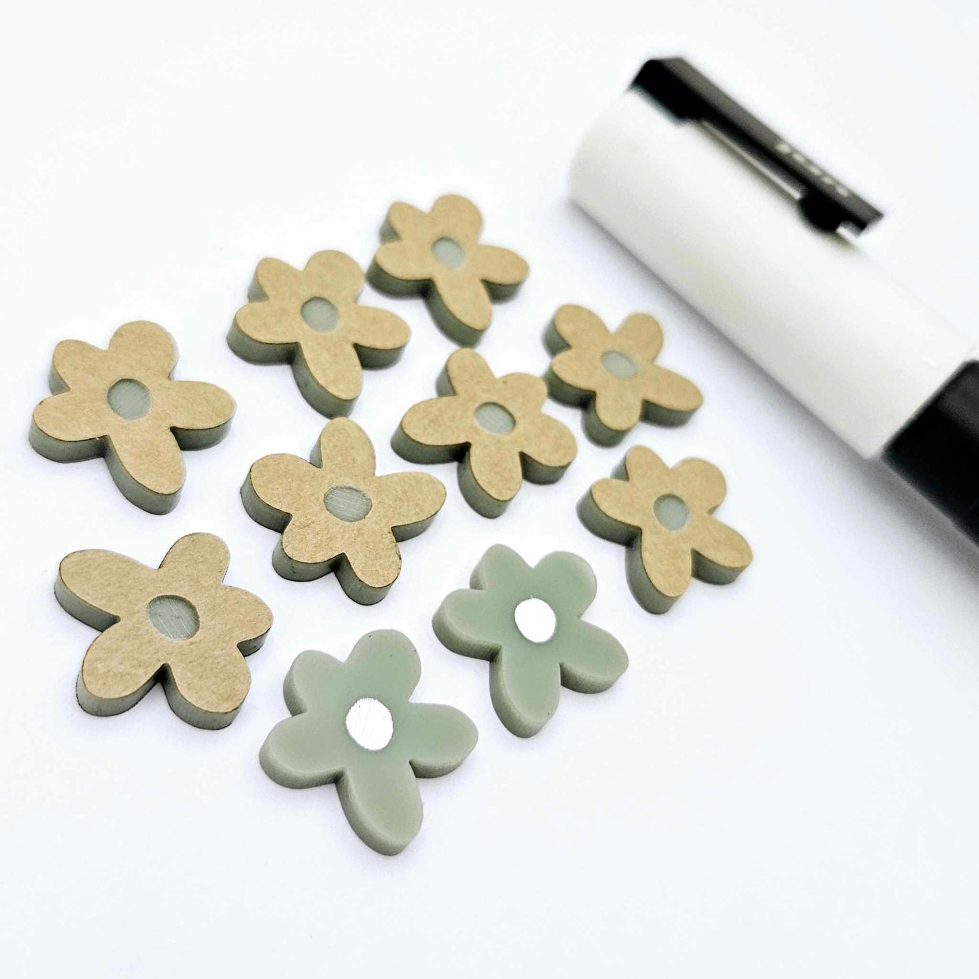 16mm olive green organic flower stud blanks showing paint filled white example and unfilled pieces with protective film, pictured with a white Posca paint pen