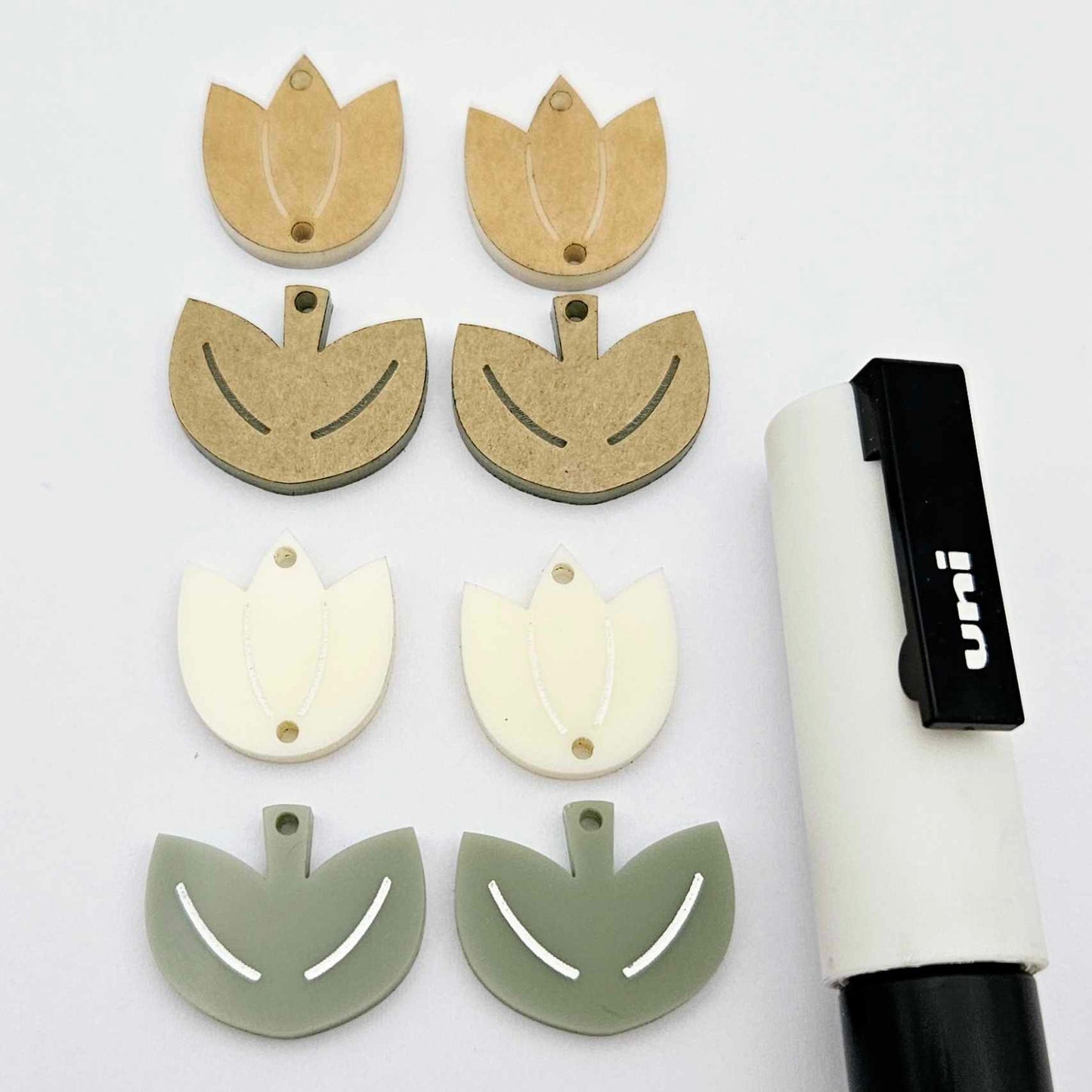 Two-piece tulip acrylic dangle blanks in cream and olive green, paint filled white on one pair with remaining pair unfilled, shown with a white Posca paint pen