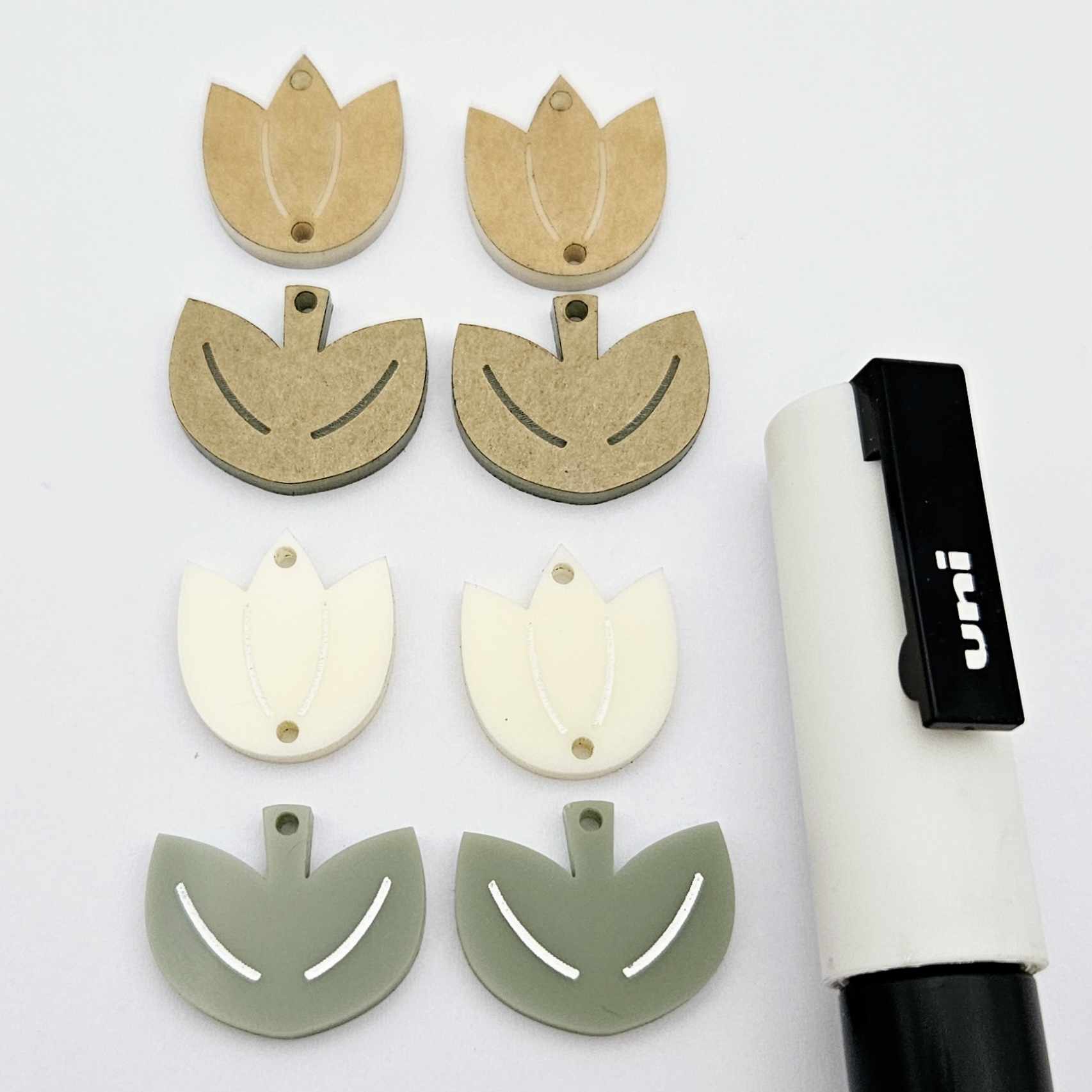 Two-piece tulip acrylic dangle blanks in cream and olive green, paint filled white on one pair with remaining pair unfilled, shown with a white Posca paint pen
