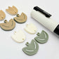 Two-piece tulip acrylic dangle blanks in cream and olive green, paint filled white on one pair with remaining pair unfilled, shown with a white Posca paint pen