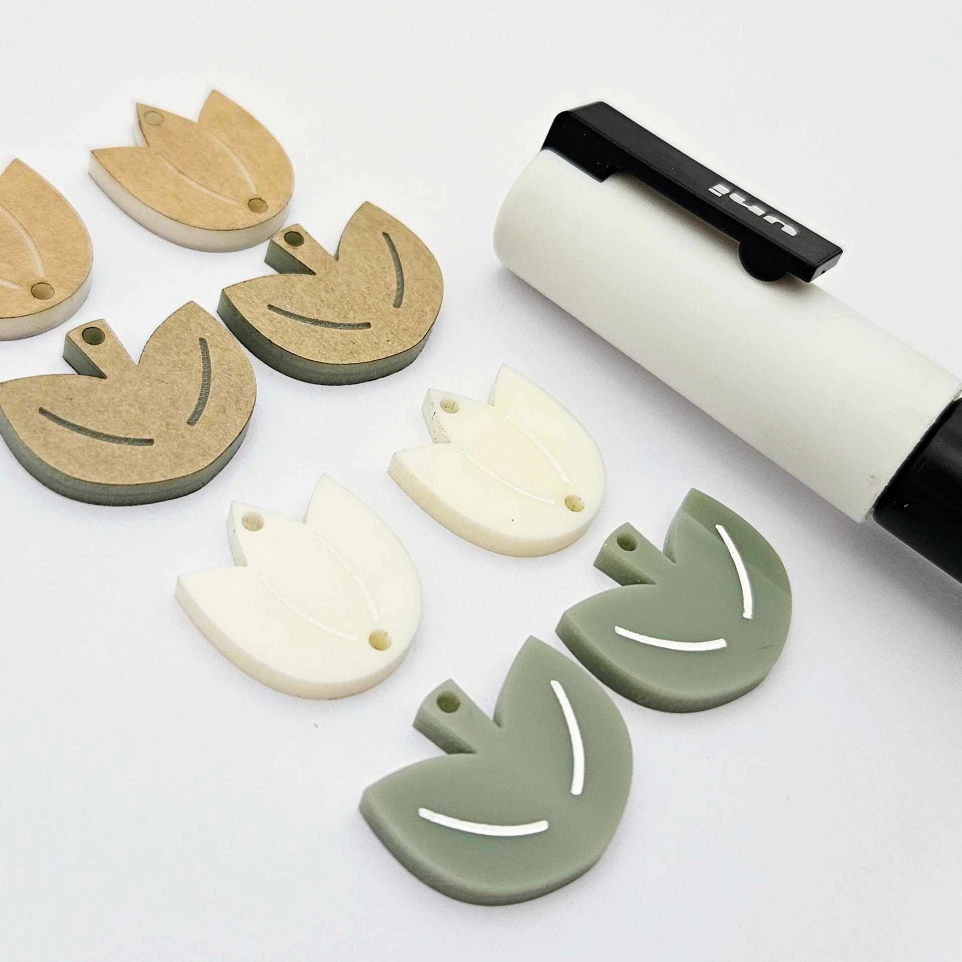 Two-piece tulip acrylic dangle blanks in cream and olive green, paint filled white on one pair with remaining pair unfilled, shown with a white Posca paint pen