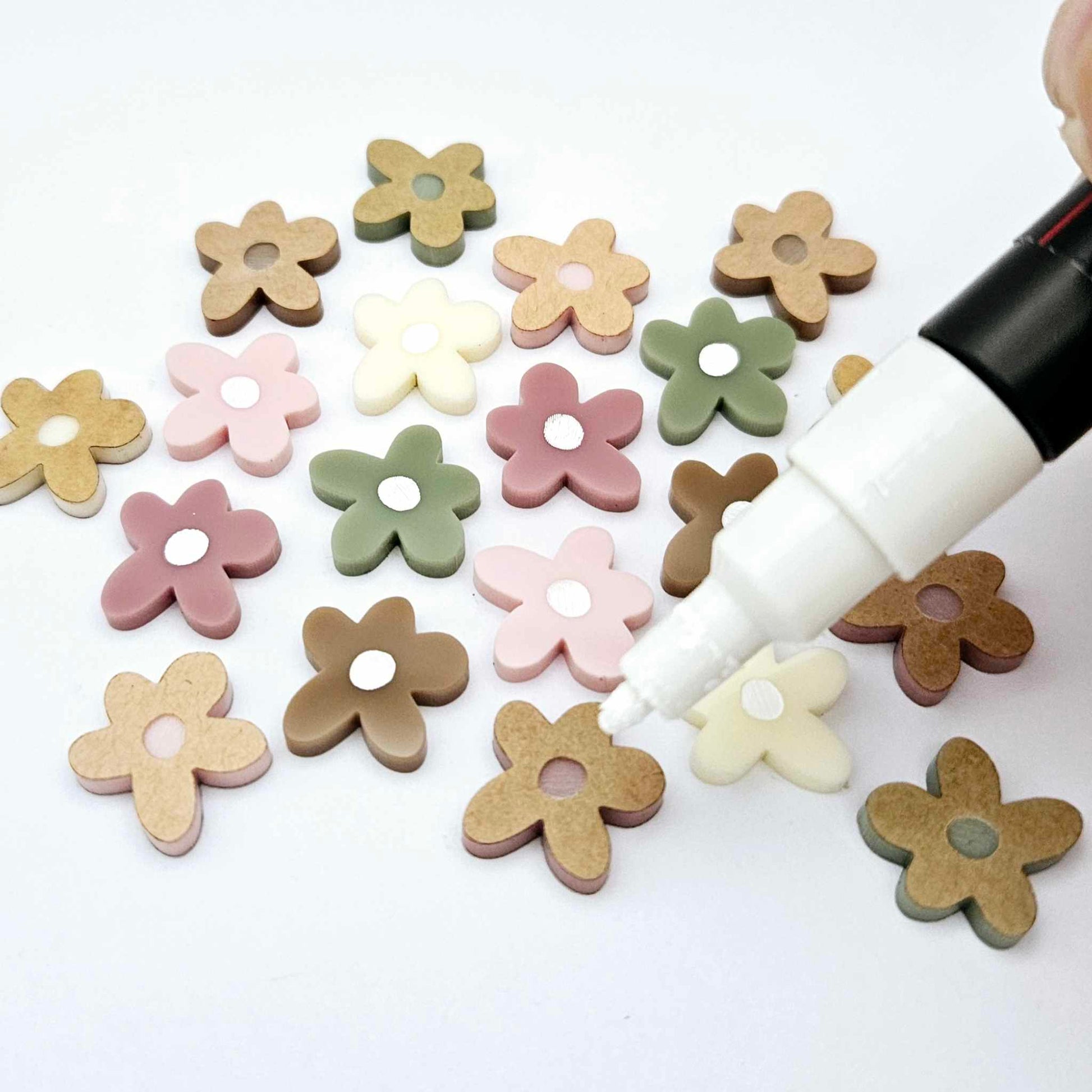16mm mixed earthy tone acrylic organic flower stud blanks with engraved centre paint filled white, shown with a white Posca Paint Pen