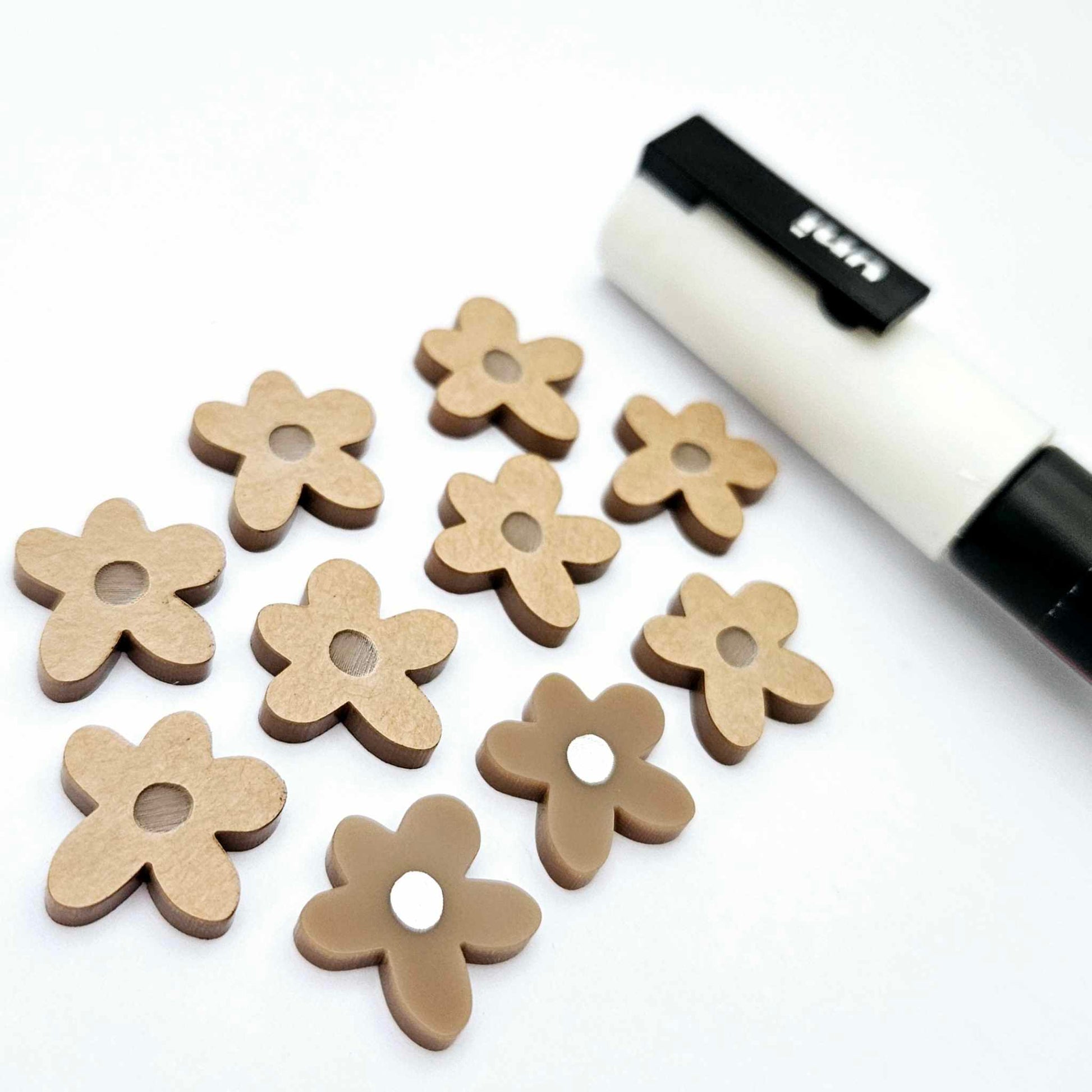 16mm iced coffee brown organic flower stud blanks showing paint filled white example and unfilled pieces with protective film, pictured with a white Posca paint pen