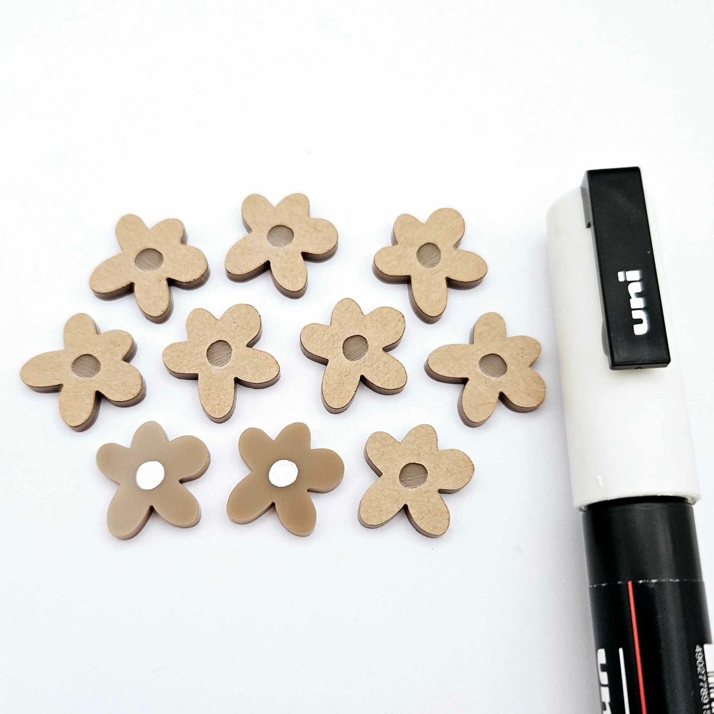 16mm iced coffee brown organic flower stud blanks showing paint filled white example and unfilled pieces with protective film, pictured with a white Posca paint pen