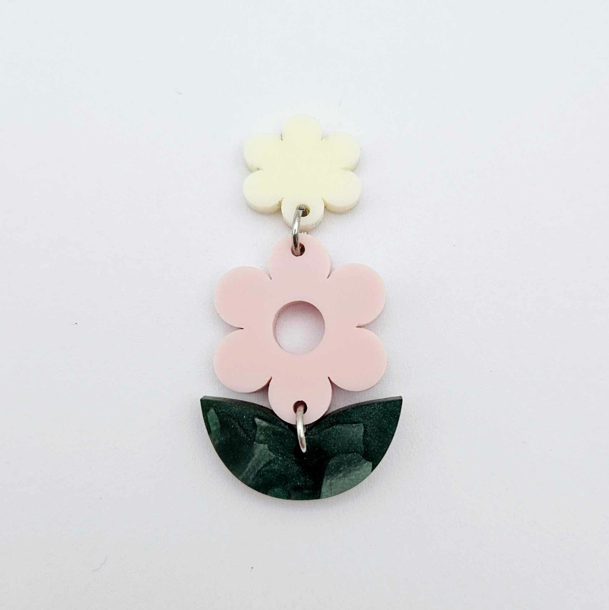 Assembled strawberry milkshake and green mineral acrylic flower dangle hanging from a cream flower topper, layered botanical earring design