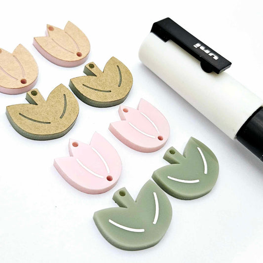 Two-piece tulip acrylic dangle blanks in dusty pale pink and olive green, paint filled white on one pair with remaining pair unfilled, shown with a white Posca paint pen