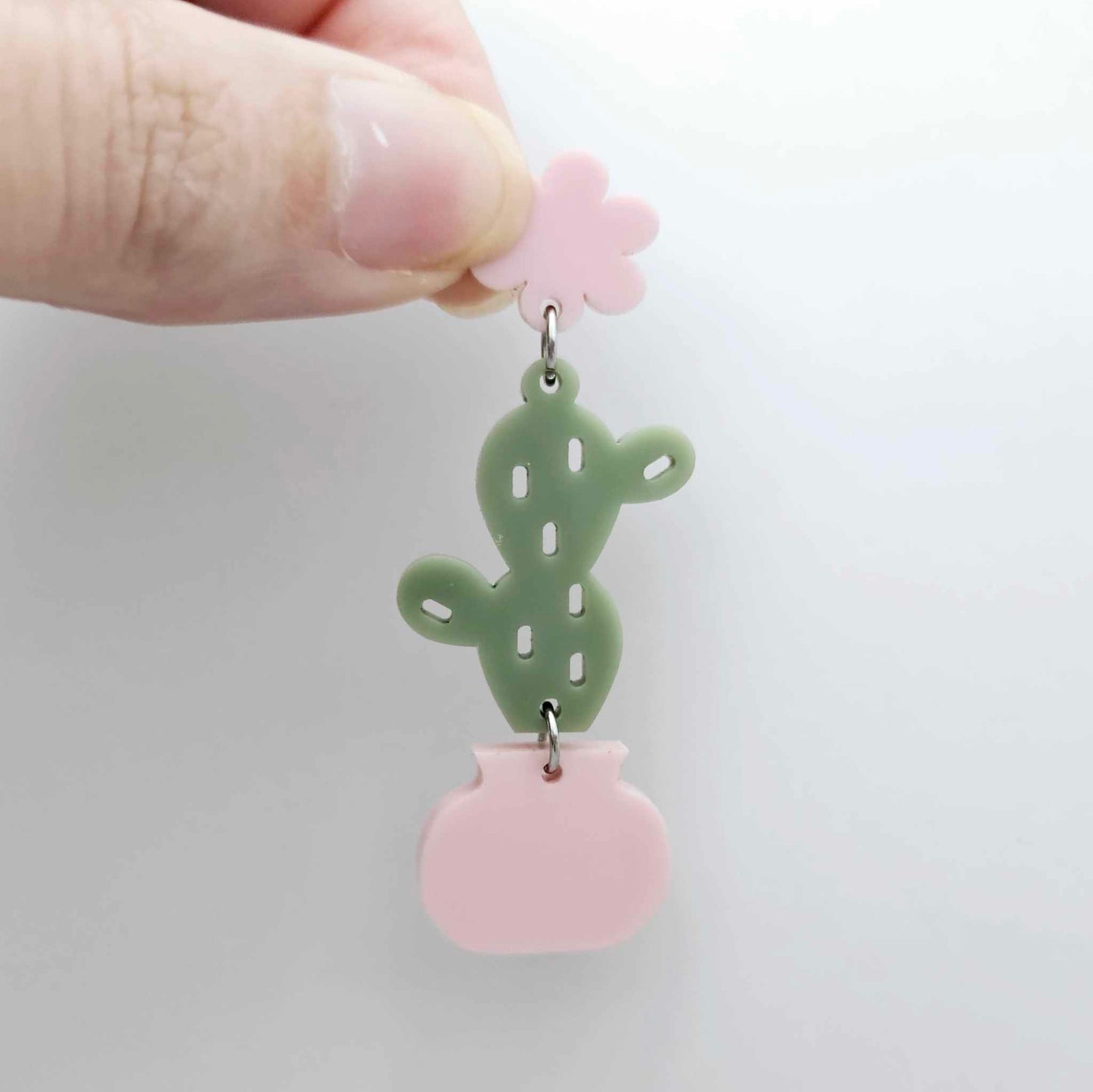 Assembled olive green acrylic cactus and pink pot dangle hanging from a 14mm strawberry milkshake flower topper
