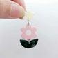 Assembled strawberry milkshake and green mineral acrylic flower dangle hanging from a cream flower topper, layered botanical earring design