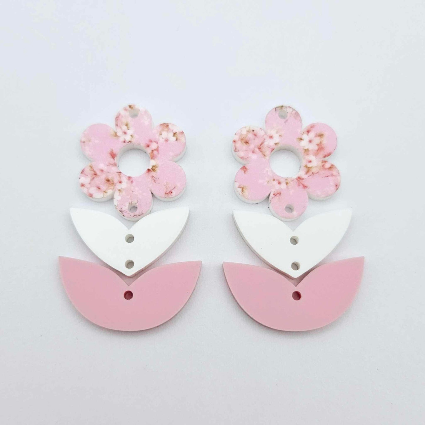 Three-piece acrylic flower dangle blanks shown unassembled laying flat, featuring Cherry Blosoom UV printed flower, white leafy middle and pastel pink leafy bottom