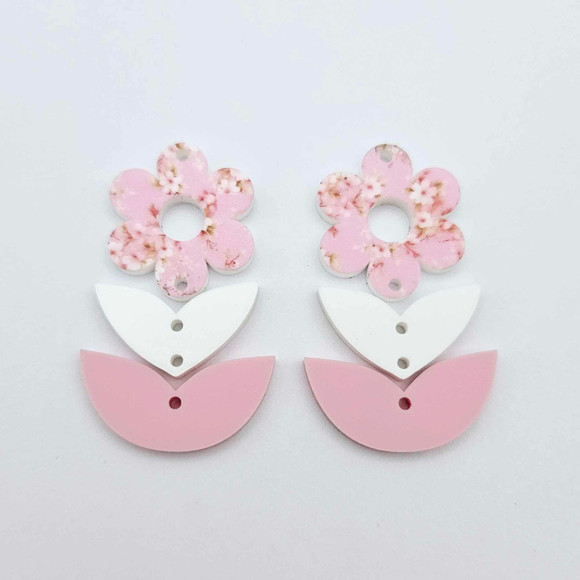 Three-piece acrylic flower dangle blanks shown unassembled laying flat, featuring Cherry Blosoom UV printed flower, white leafy middle and pastel pink leafy bottom