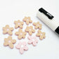 16mm dusty pale pink organic flower stud blanks showing paint filled white example and unfilled pieces with protective film, pictured with a white Posca paint pen