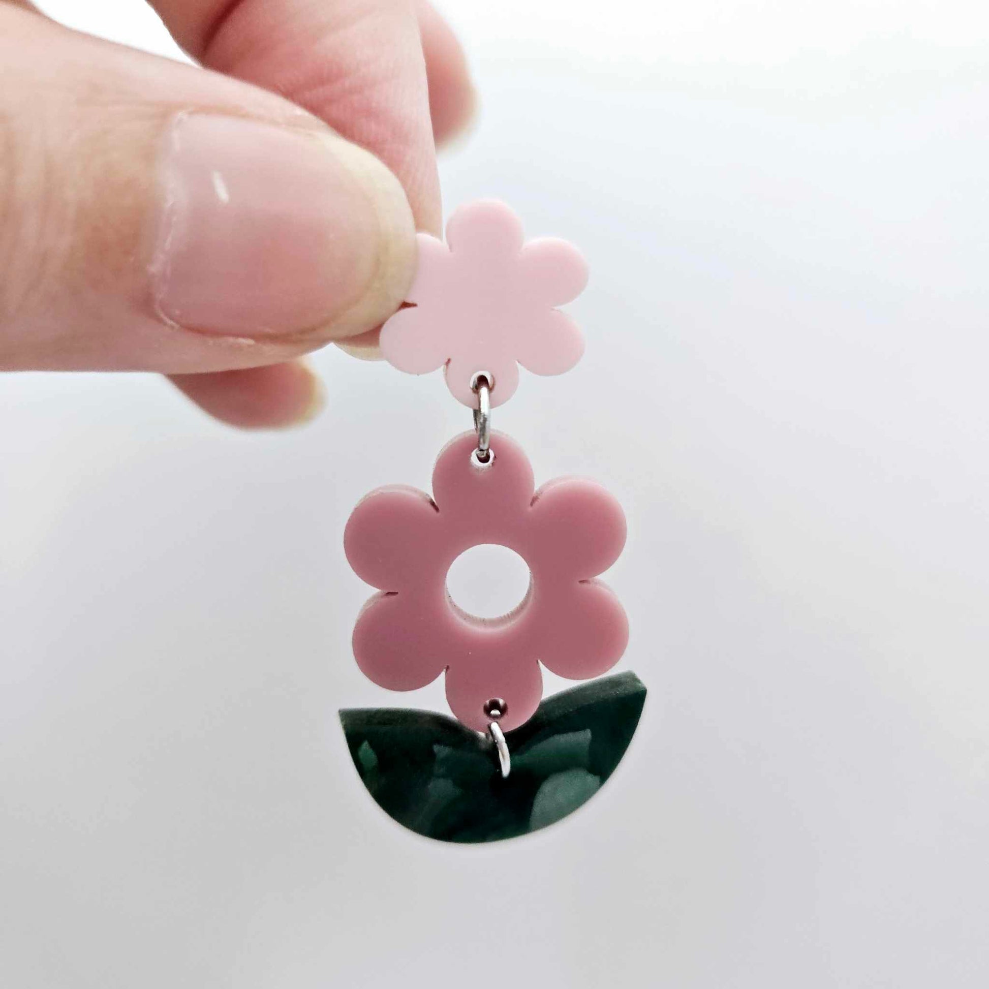 Assembled dusty rose and green mineral acrylic flower dangles hanging from strawberry milkshake flower toppers, layered botanical earring design