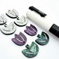 Two-piece tulip acrylic dangle blanks in purple marble and green mineral acrylic, paint filled white on one pair with remaining pair unfilled, shown with a white Posca paint pen