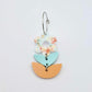 Assembled three-piece acrylic flower dangle hanging from a 20mm hoop, UV printed Floral Bloom flower with aqua and orange leaf layers