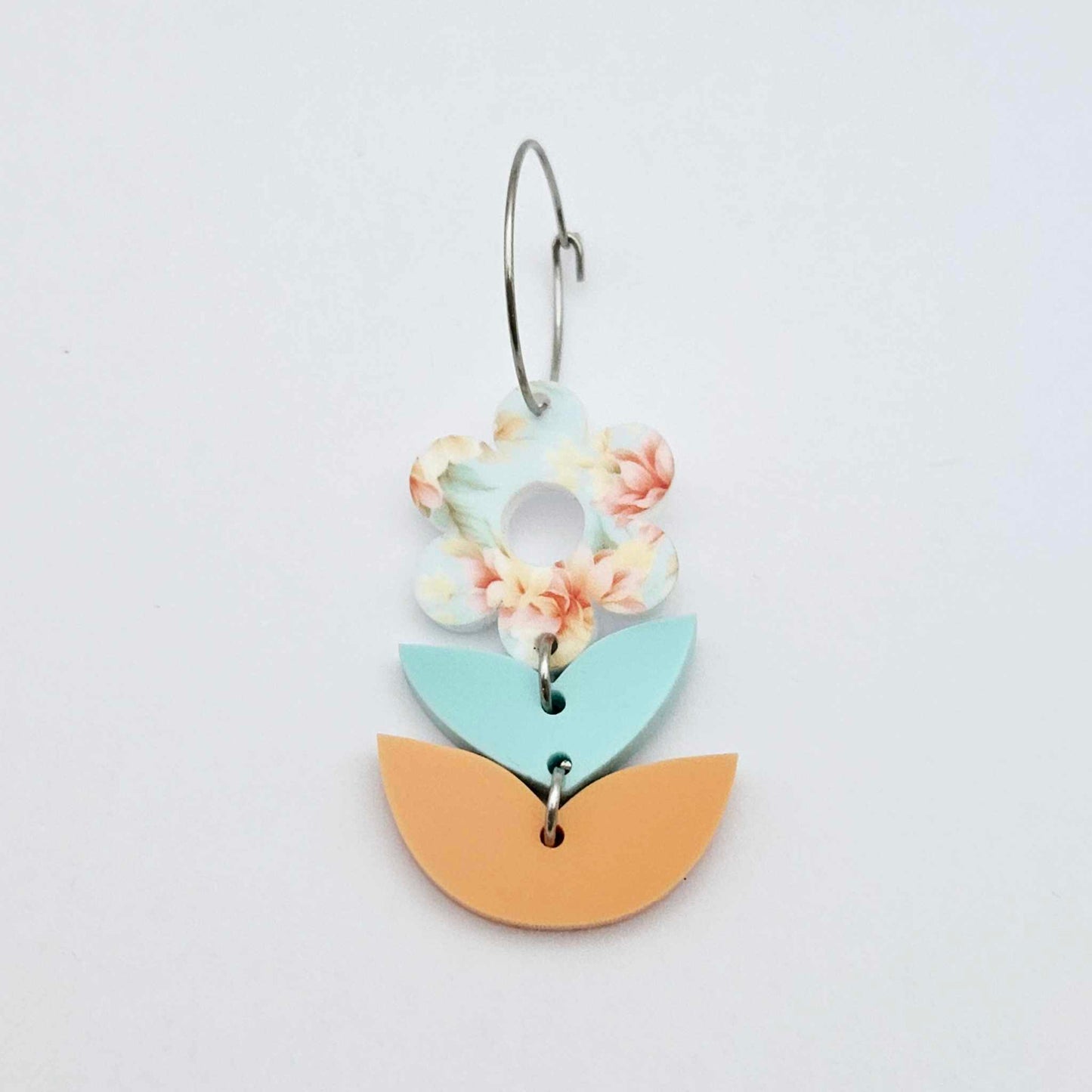 Assembled three-piece acrylic flower dangle hanging from a 20mm hoop, UV printed Floral Bloom flower with aqua and orange leaf layers