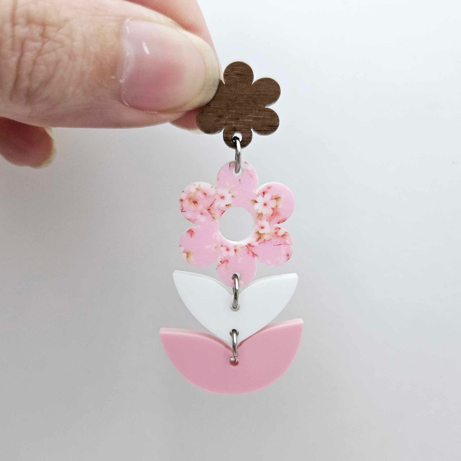 Assembled three-piece acrylic floral dangle hanging from a 14mm walnut flower topper, Cherry Blossom UV printed flower with white and pastel pink layered leaf pieces