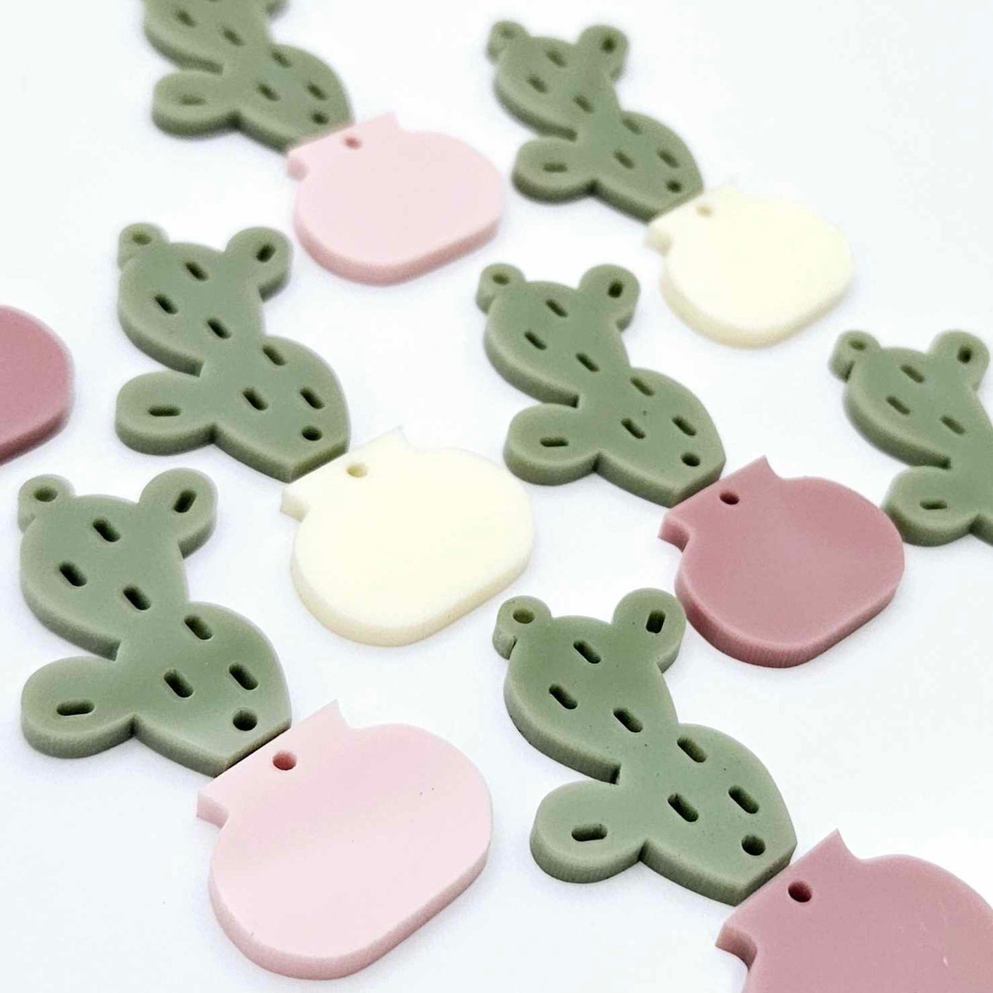 Two-piece acrylic cactus dangle blanks in olive green with mixed coloured pots, shown unassembled with cactus top and pot bottom pieces laid flat