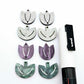 Two-piece tulip acrylic dangle blanks in purple marble and green mineral acrylic, paint filled white on one pair with remaining pair unfilled, shown with a white Posca paint pen