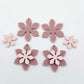 Dusty rose and strawberry milkshake two layer flower dangle blanks shown laying flat, with some flowers stacked to show layered effect and others positioned side by side