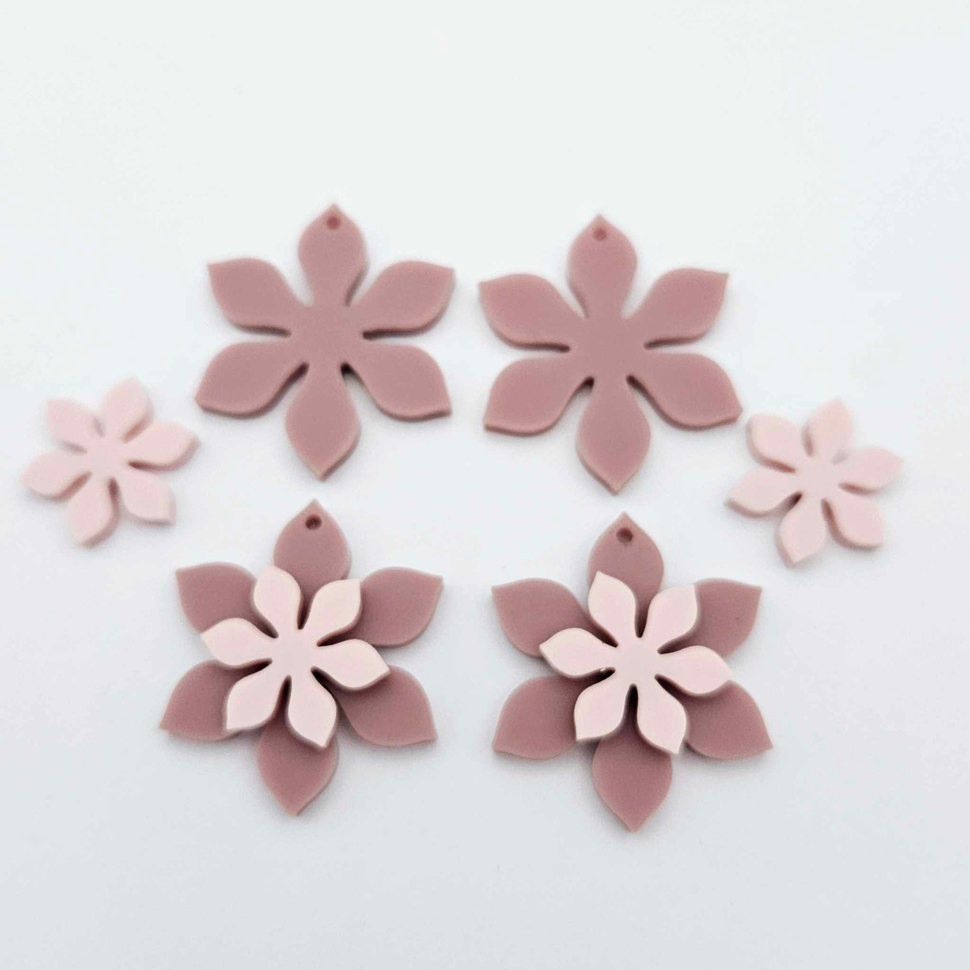 Dusty rose and strawberry milkshake two layer flower dangle blanks shown laying flat, with some flowers stacked to show layered effect and others positioned side by side