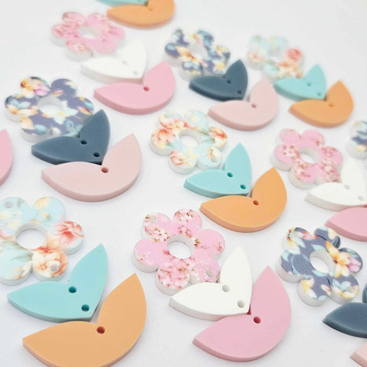 Three-piece acrylic flower dangle blanks shown unassembled laying flat, featuring  UV printed flower, solid colour leafy middle and bottom pieces