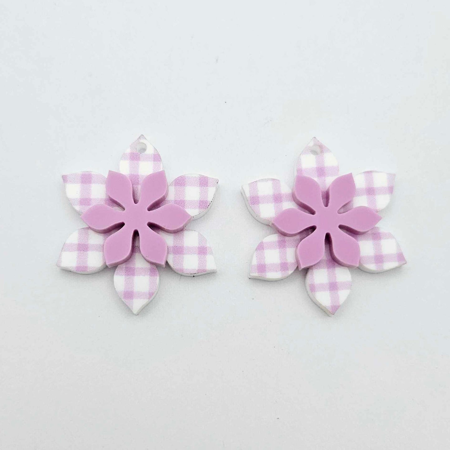 Purple gingham UV print and sour grape acrylic two layer flower dangle blanks shown laying flat, with flowers stacked to show layered effect