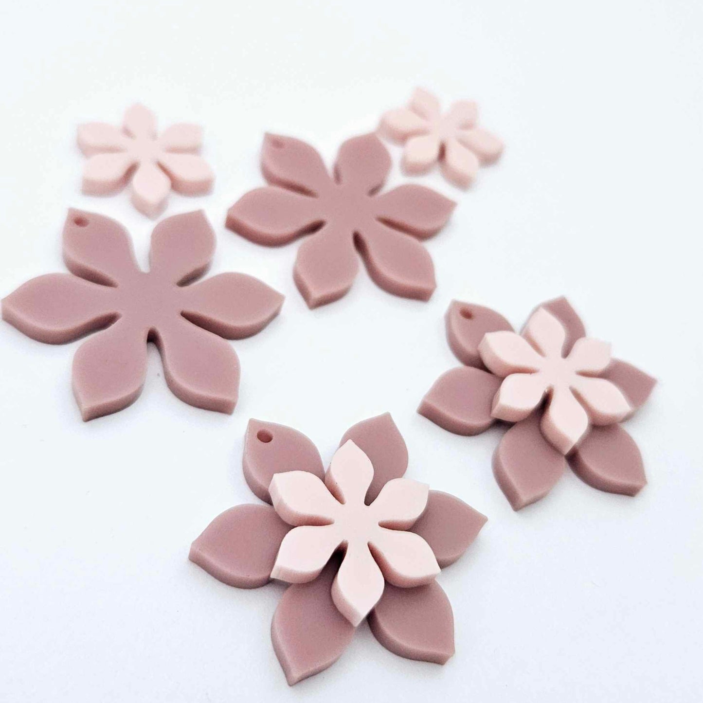 Dusty rose and strawberry milkshake two layer flower dangle blanks shown laying flat, with some flowers stacked to show layered effect and others positioned side by side