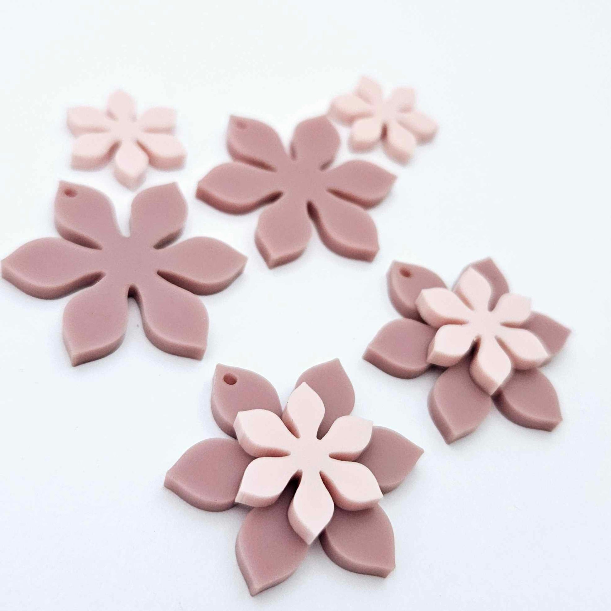 Dusty rose and strawberry milkshake two layer flower dangle blanks shown laying flat, with some flowers stacked to show layered effect and others positioned side by side