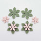 Olive Green and strawberry milkshake pink acrylic two layer flower dangle blanks shown laying flat, with some flowers stacked to show layered effect and others positioned side by side