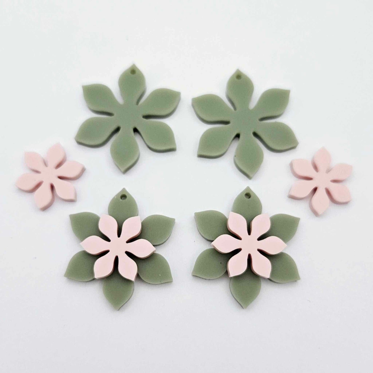 Olive Green and strawberry milkshake pink acrylic two layer flower dangle blanks shown laying flat, with some flowers stacked to show layered effect and others positioned side by side