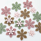 Olive Green, Iced Coffee Brown, Dusty Rose and strawberry milkshake pink acrylic two layer flower dangle blanks shown laying flat, with some flowers stacked to show layered effect and others positioned side by side