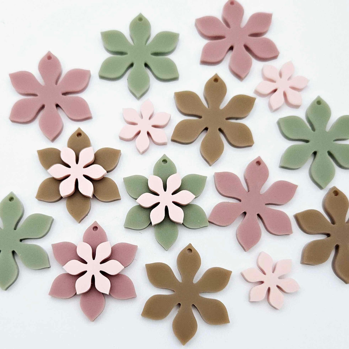 Olive Green, Iced Coffee Brown, Dusty Rose and strawberry milkshake pink acrylic two layer flower dangle blanks shown laying flat, with some flowers stacked to show layered effect and others positioned side by side