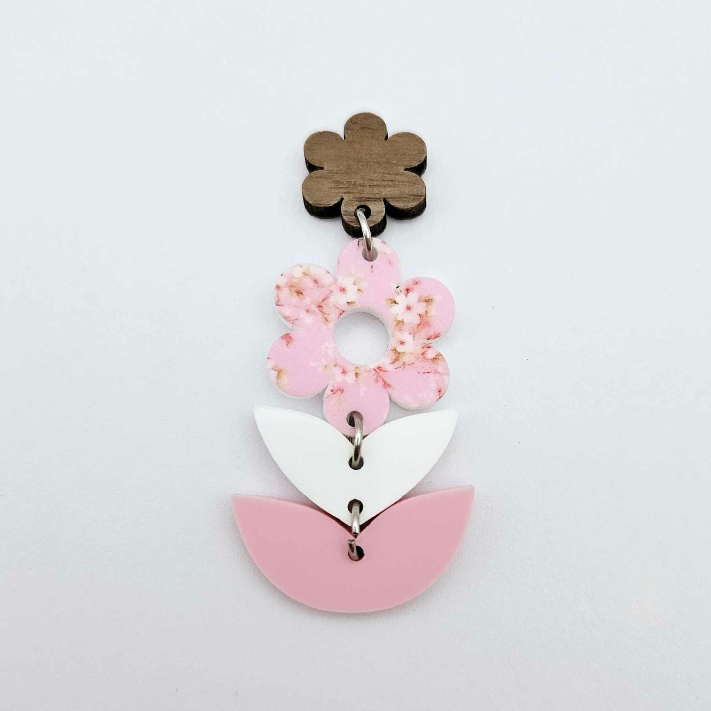 Assembled three-piece acrylic floral dangle hanging from a 14mm walnut flower topper, Cherry Blossom UV printed flower with white and pastel pink layered leaf pieces