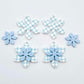 Blue gingham UV print and pastel blue acrylic two layer flower dangle blanks shown laying flat, with some flowers stacked to show layered effect and others positioned side by side