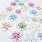 Gingham UV print and pastel acrylic two layer flower dangle blanks shown laying flat, with some flowers stacked to show layered effect and others positioned side by side